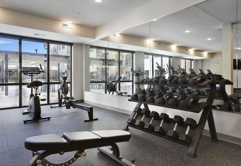 Modern fitness center with free weights and cardio equipment at The Whitney apartments in Salt Lake City, Utah