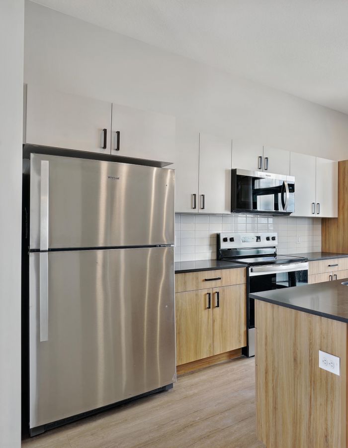 Modern apartment kitchen with stainless steel appliances at The Whitney in Salt Lake City, Utah