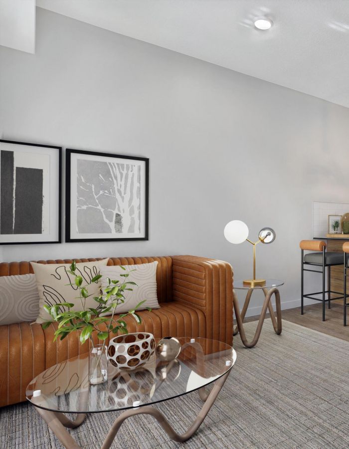 Stylish apartment lounge area with leather seating, modern décor, and glass coffee table at The Whitney luxury apartments in Salt Lake City.